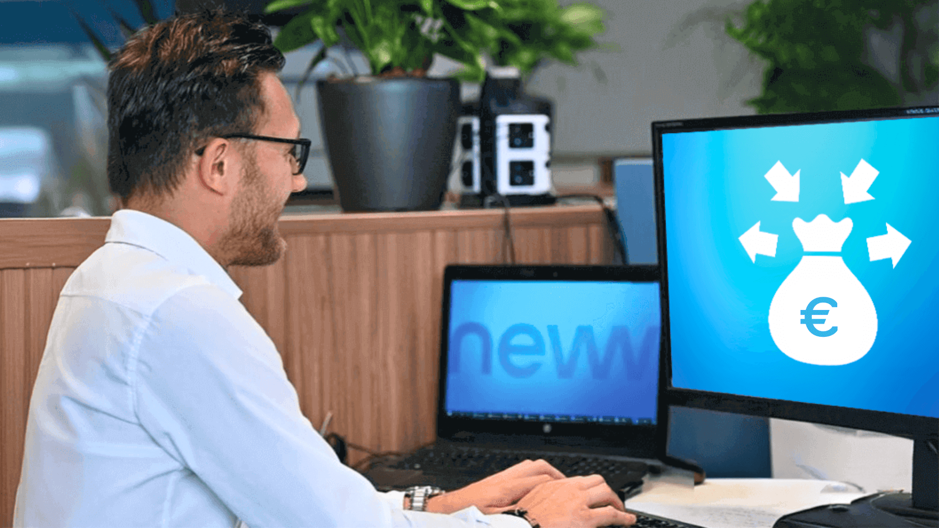 Mann am Schreibtisch mit Laptop und Monitor erstellt im Büro eine Liquiditätsplanung mit Vorlage